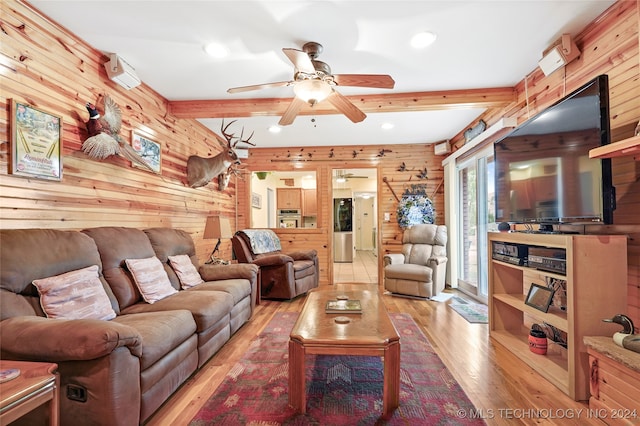 living room with light hardwood / wood-style flooring, wooden walls, beam ceiling, and ceiling fan