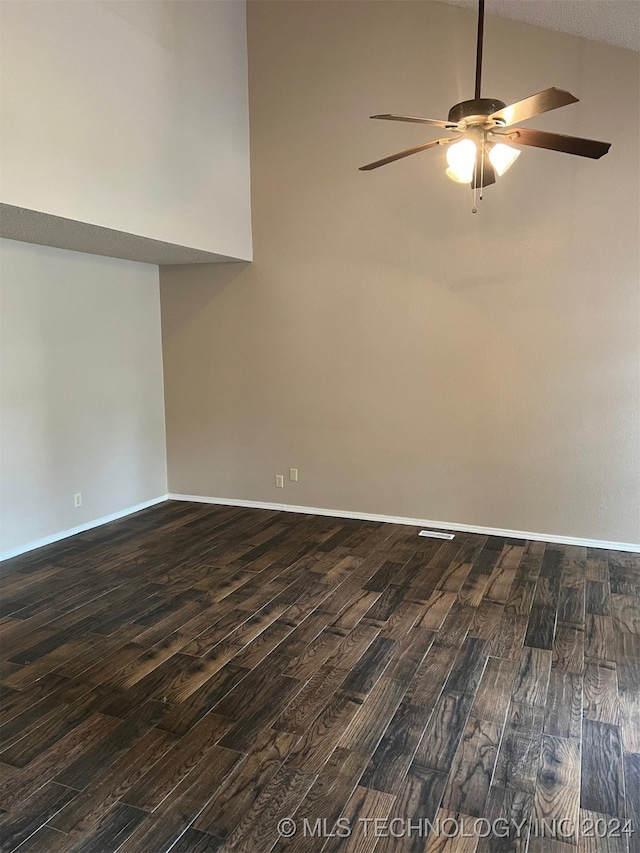 spare room featuring lofted ceiling, ceiling fan, dark wood-type flooring, and a textured ceiling