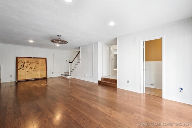 unfurnished living room featuring wooden walls and hardwood / wood-style flooring