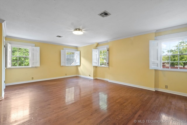 empty room featuring hardwood / wood-style flooring and crown molding