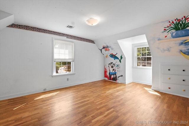 bonus room featuring lofted ceiling, light hardwood / wood-style floors, and a healthy amount of sunlight