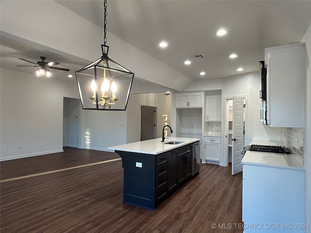 kitchen featuring a center island with sink, white cabinetry, dark wood-type flooring, pendant lighting, and decorative backsplash