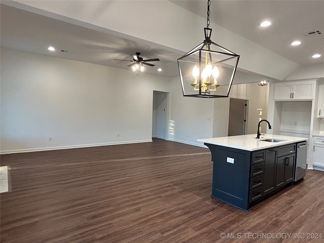 kitchen with white cabinets, hanging light fixtures, sink, and an island with sink