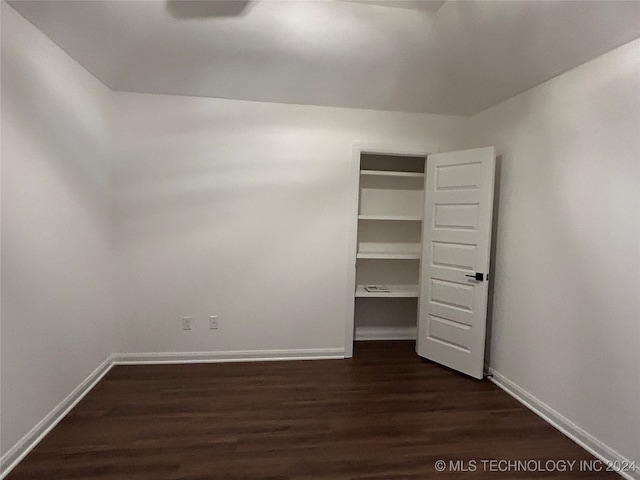 unfurnished bedroom featuring dark hardwood / wood-style flooring and a closet