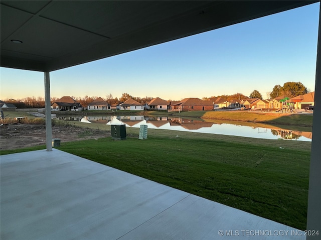 yard at dusk with a playground and a water view