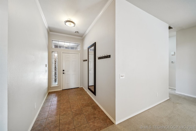 carpeted foyer entrance featuring a healthy amount of sunlight and ornamental molding