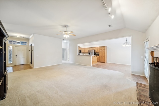 unfurnished living room with vaulted ceiling, light tile patterned floors, ceiling fan with notable chandelier, and a brick fireplace