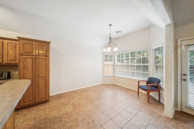 interior space with light tile patterned floors, vaulted ceiling, and an inviting chandelier