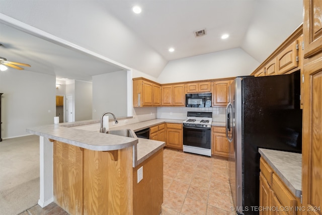 kitchen featuring kitchen peninsula, light carpet, vaulted ceiling, ceiling fan, and black appliances