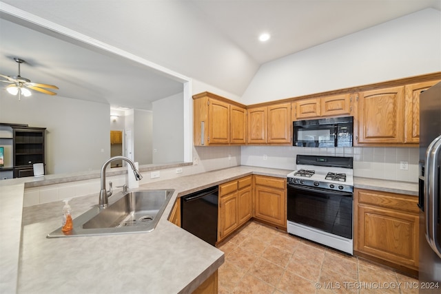 kitchen featuring ceiling fan, sink, kitchen peninsula, vaulted ceiling, and black appliances