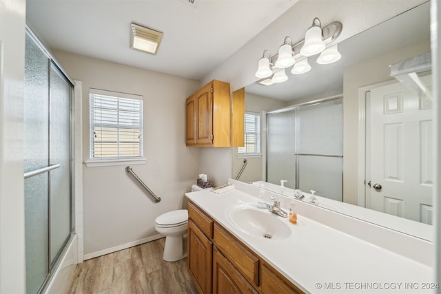 full bathroom featuring hardwood / wood-style floors, vanity, a healthy amount of sunlight, and toilet