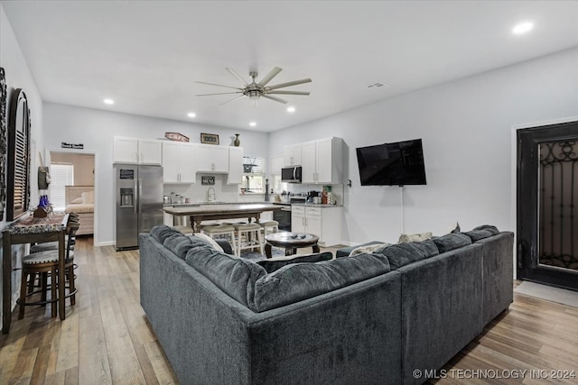 living room with ceiling fan and light wood-type flooring