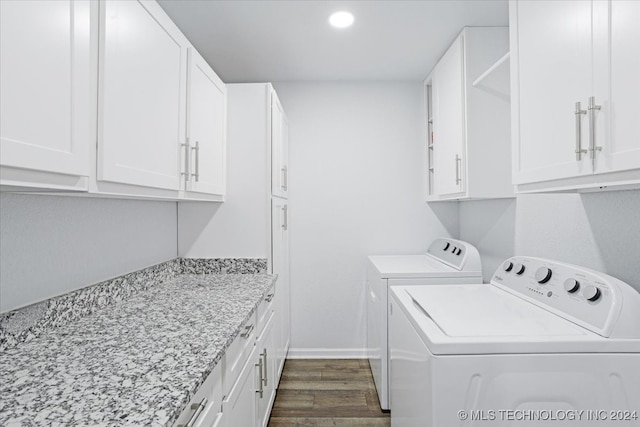 laundry room featuring washer and clothes dryer, cabinets, and dark hardwood / wood-style floors