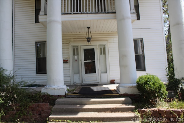 view of exterior entry featuring a balcony