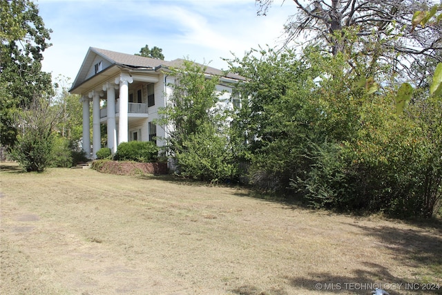 exterior space featuring a yard and a balcony