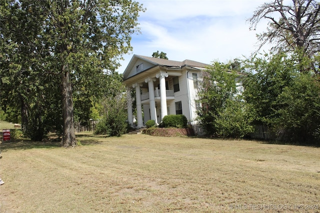 512 N 4th St, Henryetta, OK 74437 - view of front facade featuring fence, a front yard, and a balcony