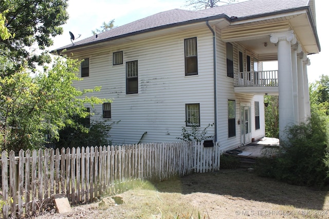 512 N 4th St, Henryetta, OK 74437 - view of side of property featuring a balcony, roof with shingles, and fence