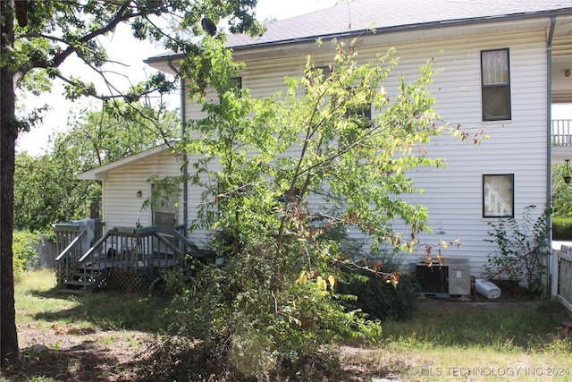 512 N 4th St, Henryetta, OK 74437 - rear view of house featuring roof with shingles, a wooden deck, and central AC