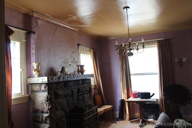 living area featuring a notable chandelier, ornamental molding, and a wealth of natural light