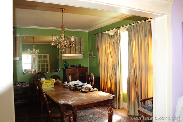 dining space with an inviting chandelier, ornamental molding, and hardwood / wood-style flooring