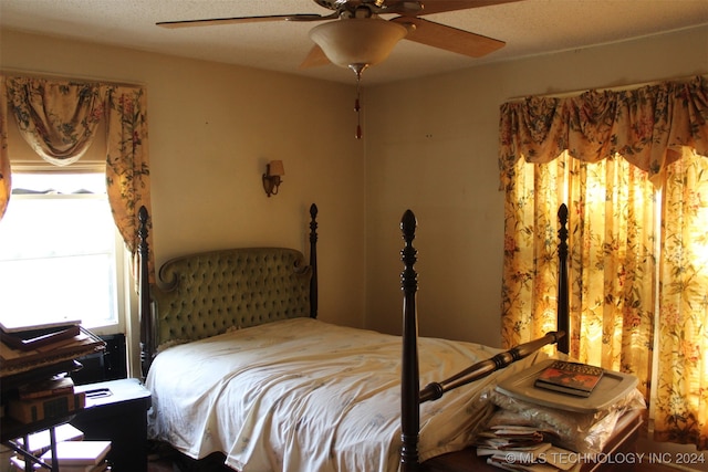 bedroom with ceiling fan and a textured ceiling