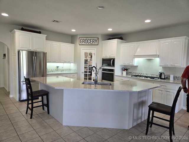 kitchen with stainless steel appliances, white cabinetry, a spacious island, and custom exhaust hood