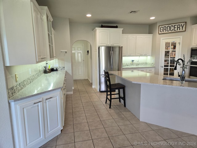 kitchen with white cabinetry, sink, light tile patterned floors, and stainless steel appliances