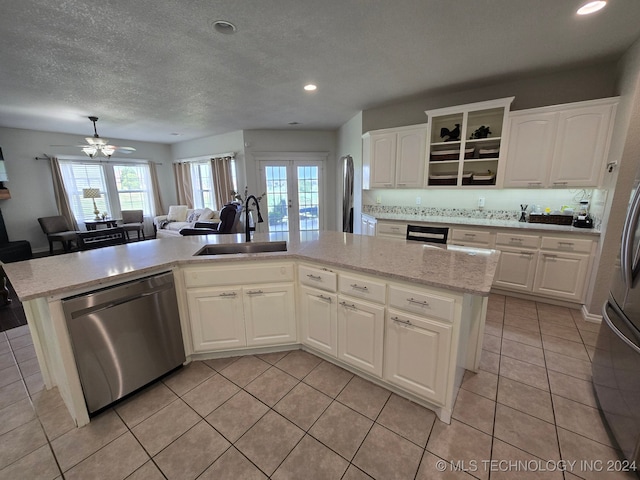 kitchen featuring dishwasher, sink, an island with sink, white cabinets, and ceiling fan