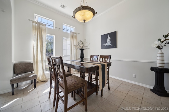 dining area with light tile patterned floors and ornamental molding