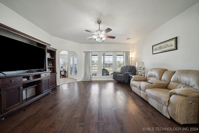 living room featuring ceiling fan and dark hardwood / wood-style floors