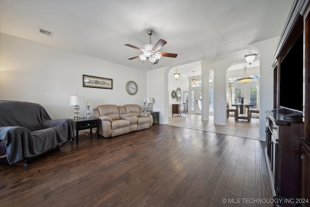 living room with ceiling fan and dark wood-type flooring