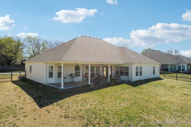 rear view of house with a lawn and a patio area