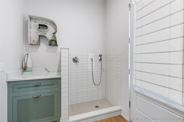 bathroom with wood-type flooring and tiled shower