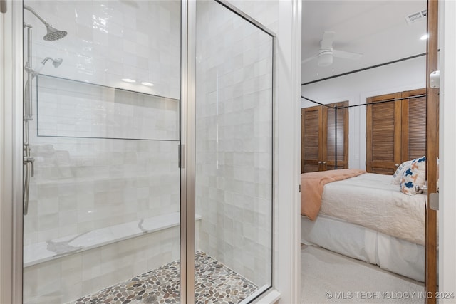 bathroom with a shower with door and ceiling fan