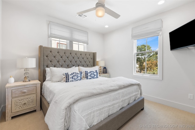 bedroom with multiple windows, light colored carpet, and ceiling fan