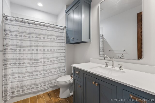 bathroom with wood-type flooring, vanity, and toilet