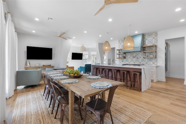 dining room featuring light wood-type flooring, ceiling fan, and sink