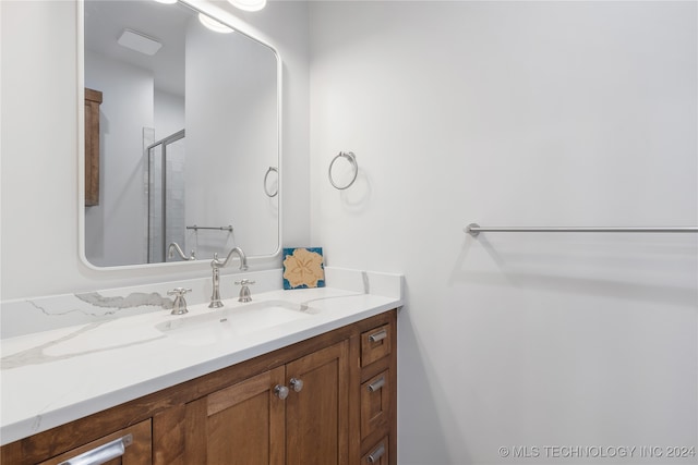 bathroom with vanity and a shower with door