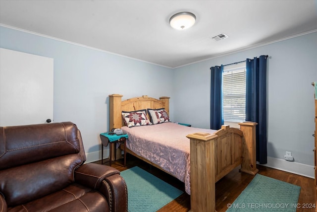 bedroom with dark wood-type flooring and crown molding