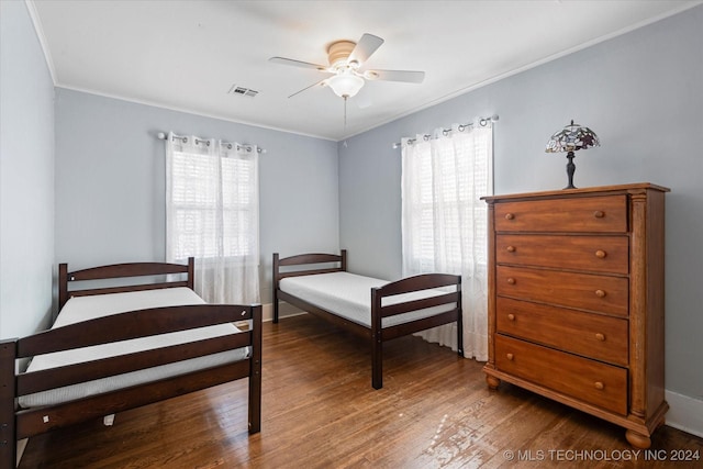 bedroom featuring ceiling fan, ornamental molding, and hardwood / wood-style floors