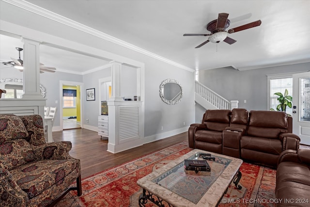 living room featuring ceiling fan, dark wood-type flooring, ornamental molding, and ornate columns