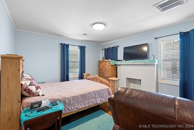 bedroom featuring multiple windows, ornamental molding, and hardwood / wood-style floors