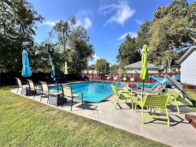 view of pool with a patio area and a yard