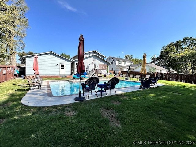 view of pool featuring a patio area and a yard