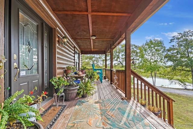 wooden terrace with a porch and a water view