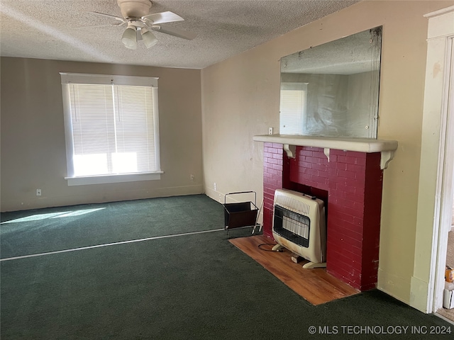 unfurnished living room featuring a textured ceiling, dark colored carpet, heating unit, and ceiling fan