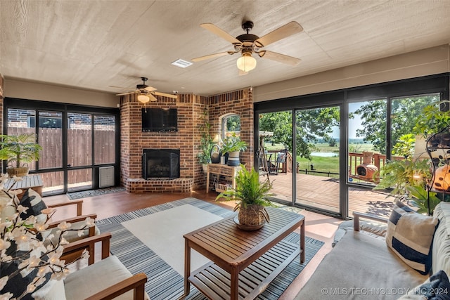 living room featuring ceiling fan and a brick fireplace