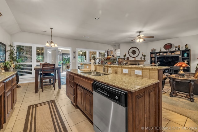 kitchen with stainless steel dishwasher, sink, pendant lighting, light tile patterned floors, and a center island with sink