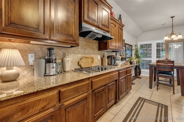 kitchen with stainless steel gas stovetop, backsplash, light tile patterned floors, decorative light fixtures, and a chandelier