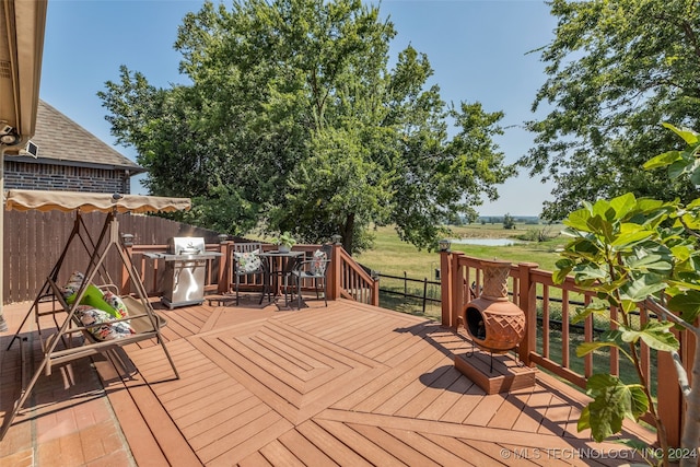 wooden terrace with a lawn and a water view